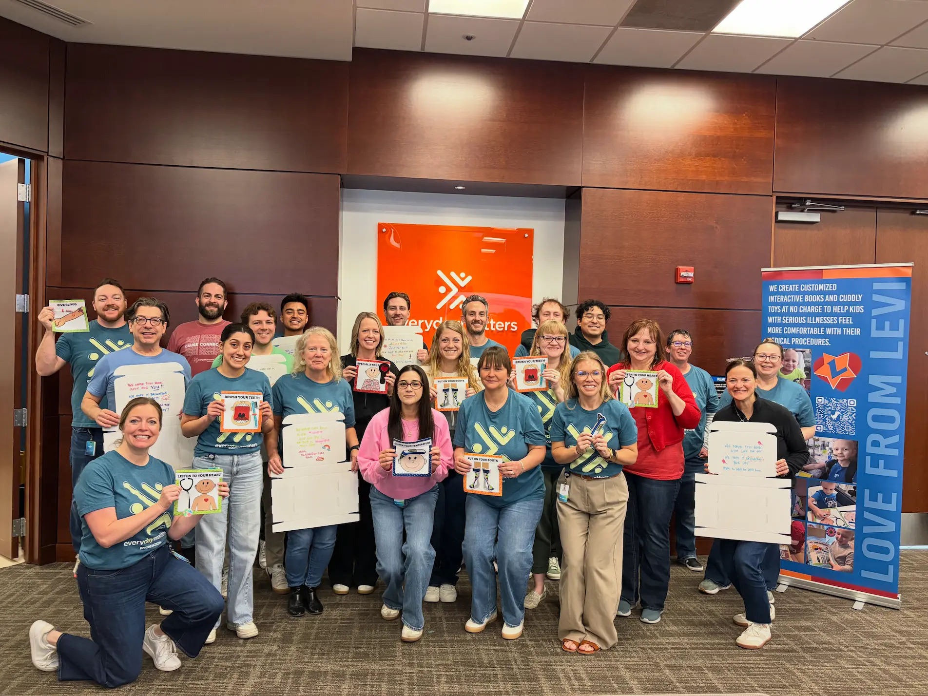 A group of volunteers in recycling shirts holding collection bags at a shoreline cleanup